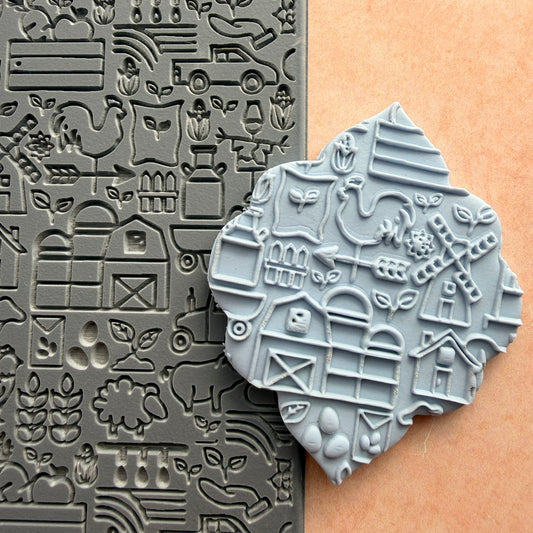 On the Farm rubber stamp beside impressed polymer clay piece showing barn windmill rooster and farm scene detail