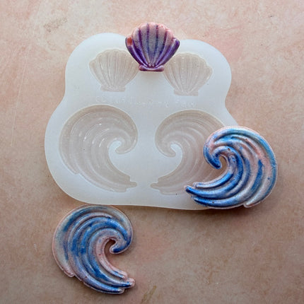 Shells and Swells silicone mold with baked polymer clay wave and shell earring pieces showing blue and pink shimmer finish