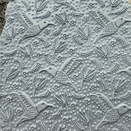 Hummingbird Flight rubber stamp impressed into polymer clay slab showing full all-over hummingbird and floral pattern