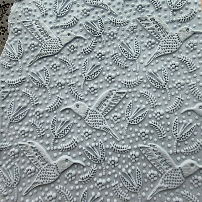 Hummingbird Flight rubber stamp impressed into polymer clay slab showing full all-over hummingbird and floral pattern