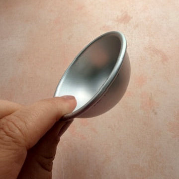 Little Luna Dome 2 inch aluminum baking form for polymer clay held in hand showing profile view